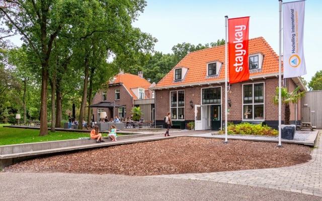 Het gebouw van Stayokay Soest, met rode daken en een rode vlag